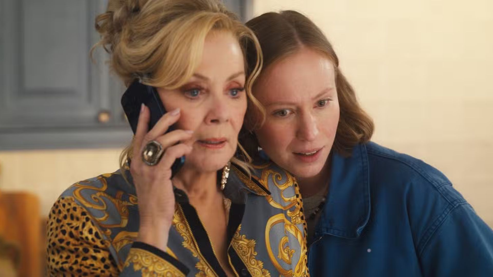 Ava leans towards Deborah while she's on the phone