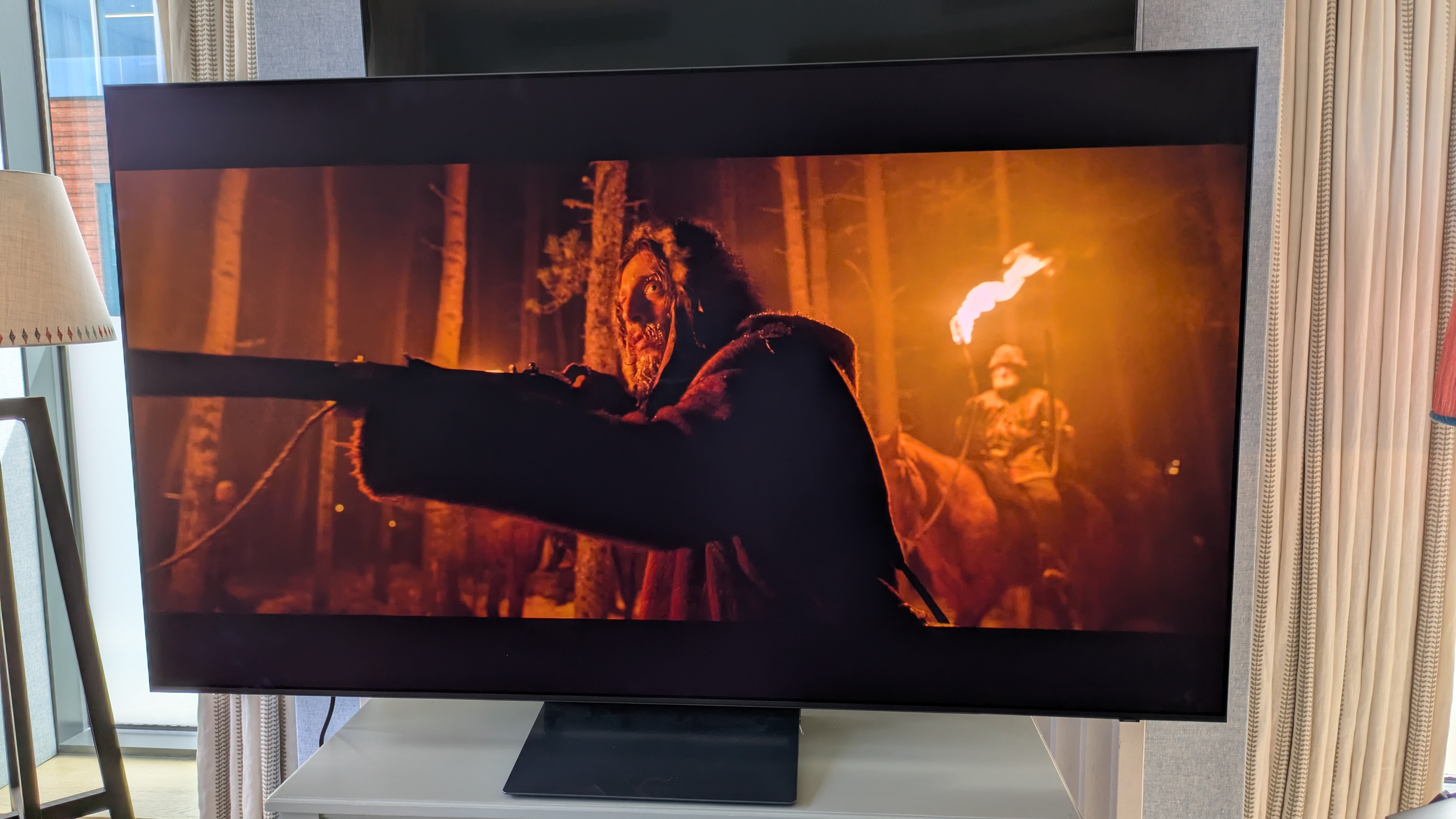 Samsung S90H OLED TV with a man holding a gun from The Revenant on screen