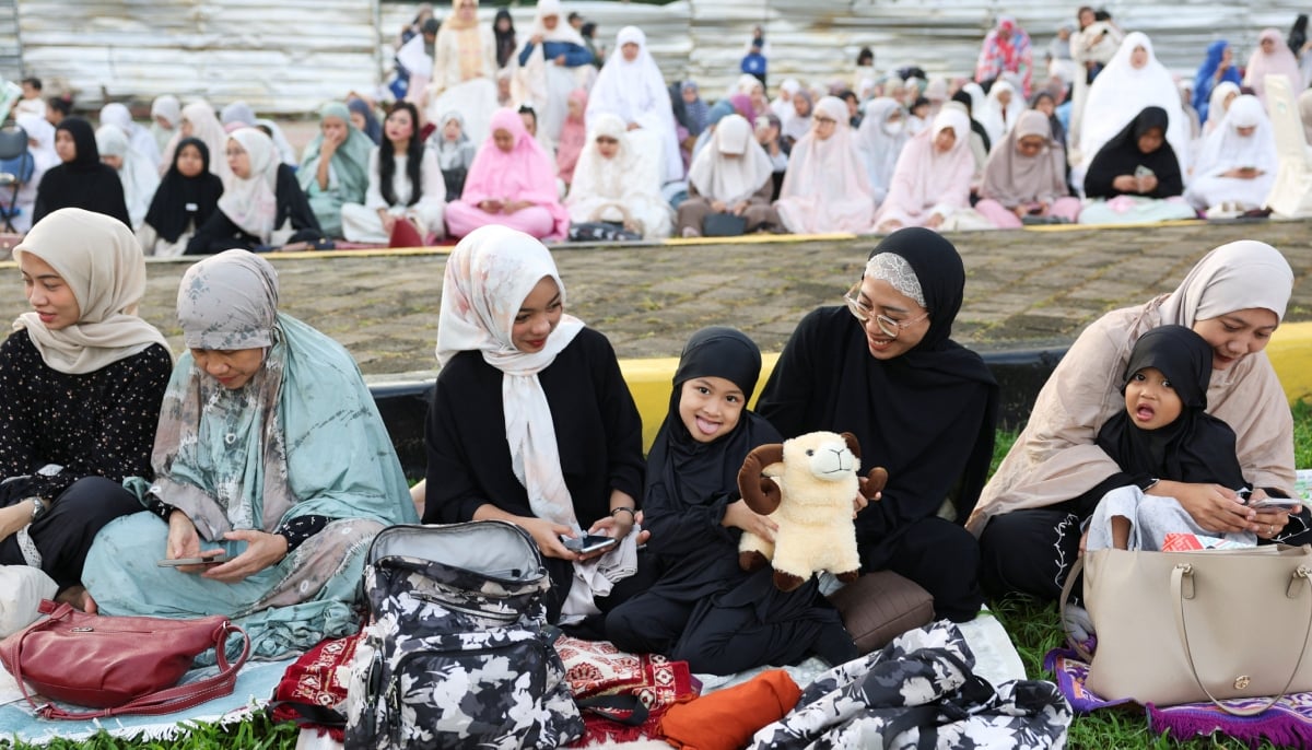 A young girl holds a doll as she prepares to offer mass Eid ul Adha prayers at the Al Azhar Grand Mosque in Jakarta, Indonesia, May 27, 2026. — Reuters