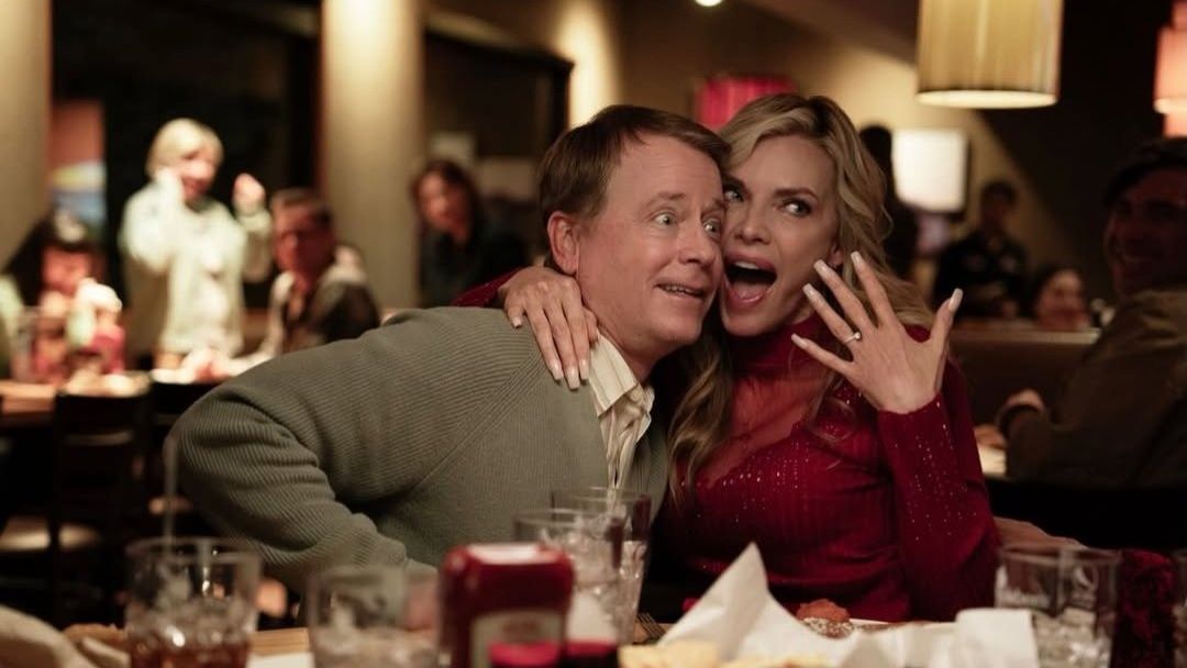 Greg Kinnear and Michelle Pfieffer in Margo's Got Money Troubles. Pfieffer's character excitedly shows off her engagement ring.