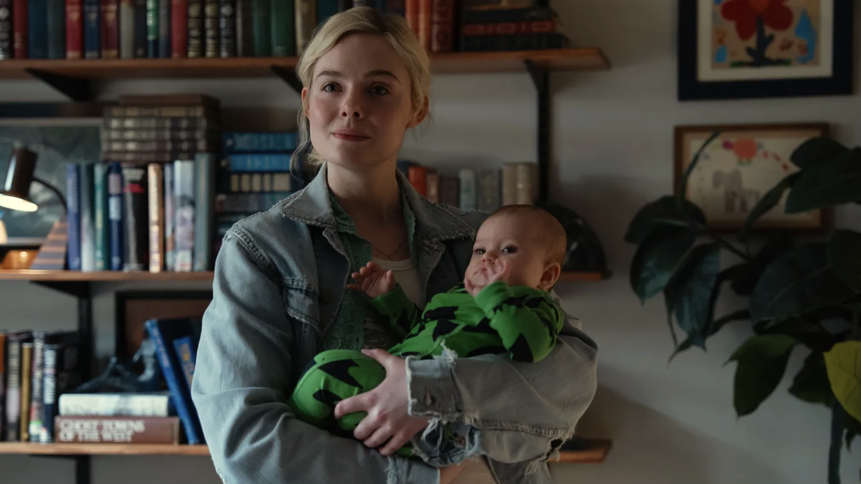 Elle Fanning as Margo Millet, holding baby Bodhi in her arms