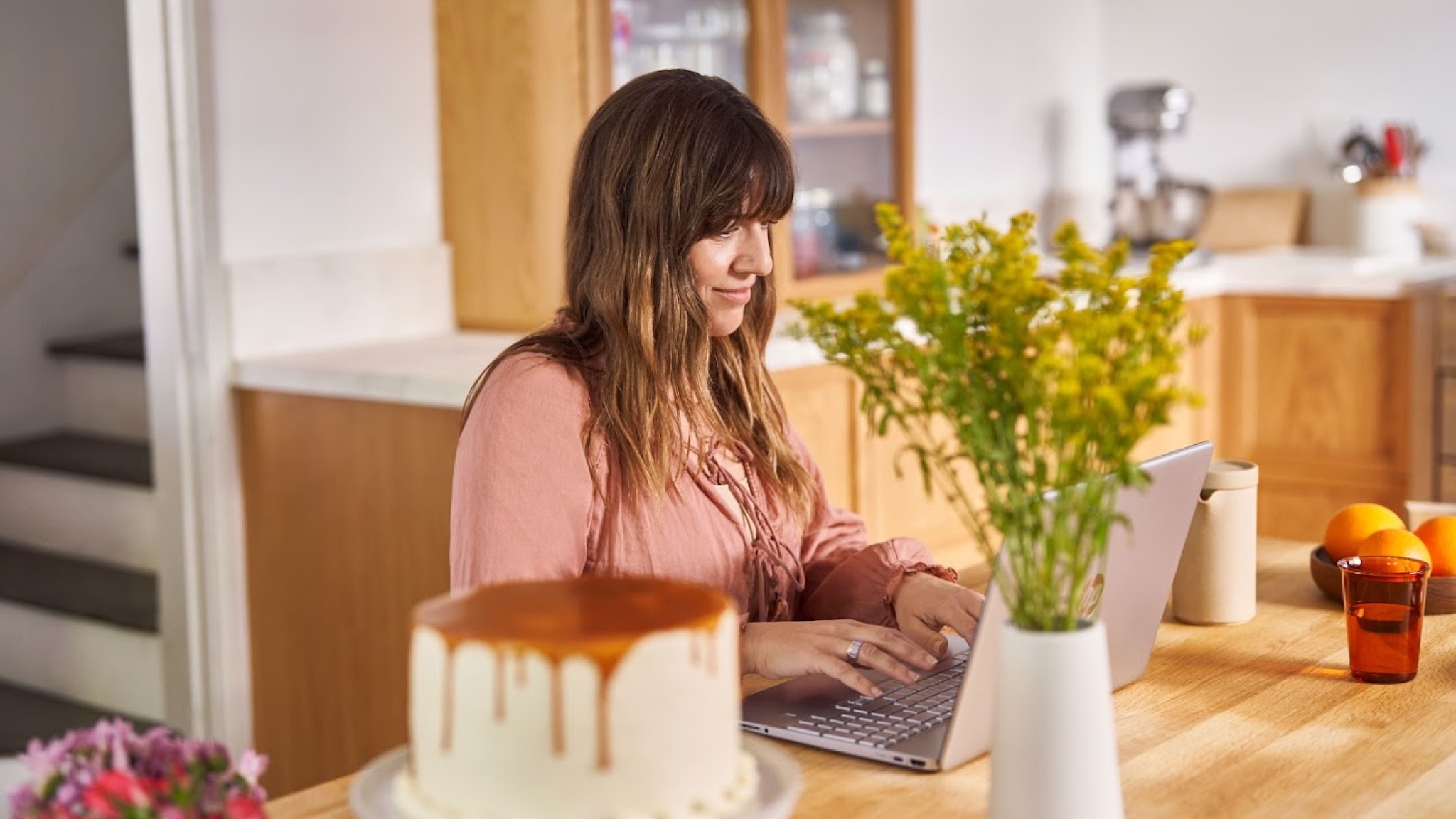 A person using a Windows 11 laptop at a desk smiling