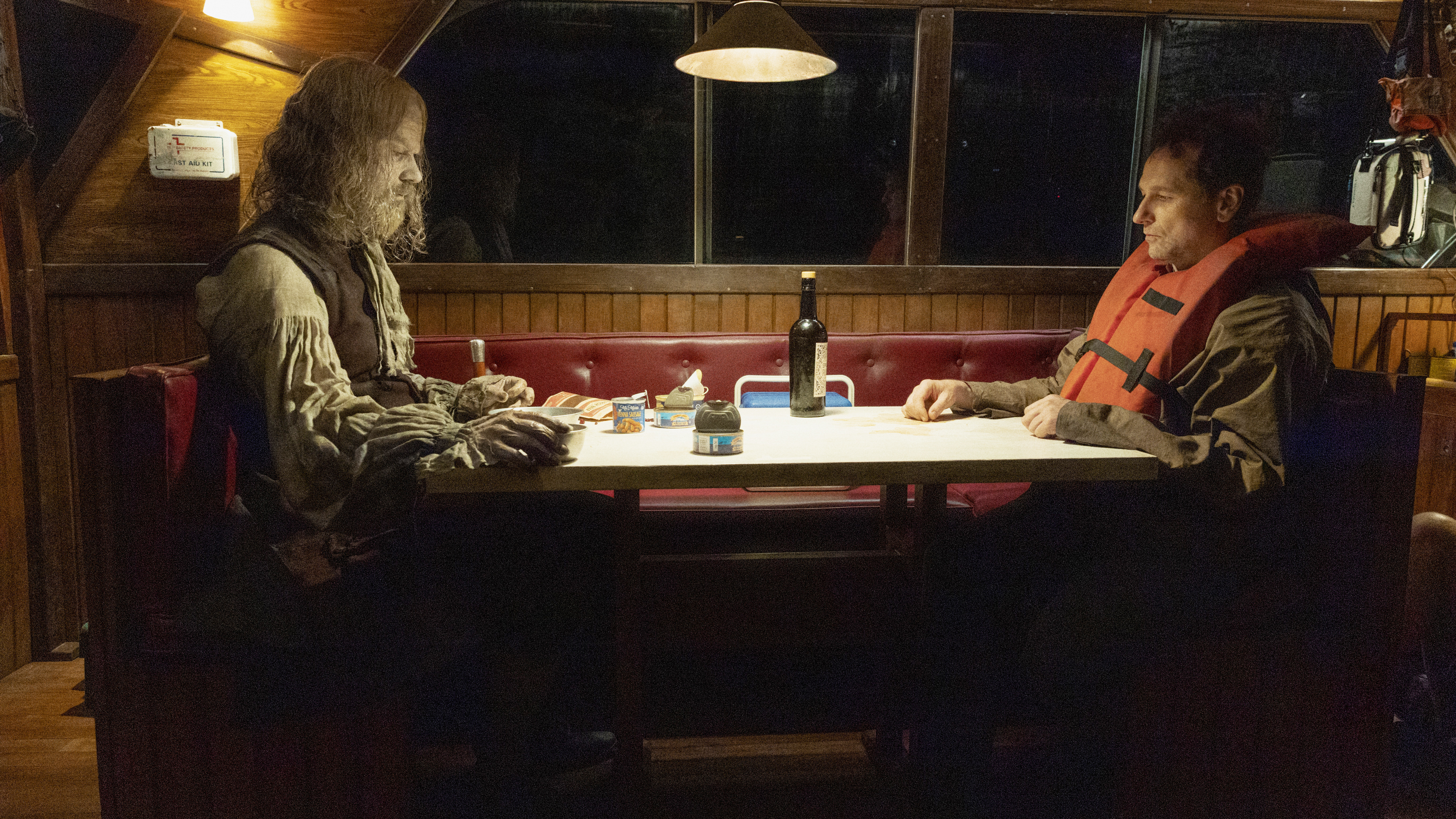 A zombified Richard Warren sitting across from Tom Loftis on a boat at night in episode 7 of Widow's Bay