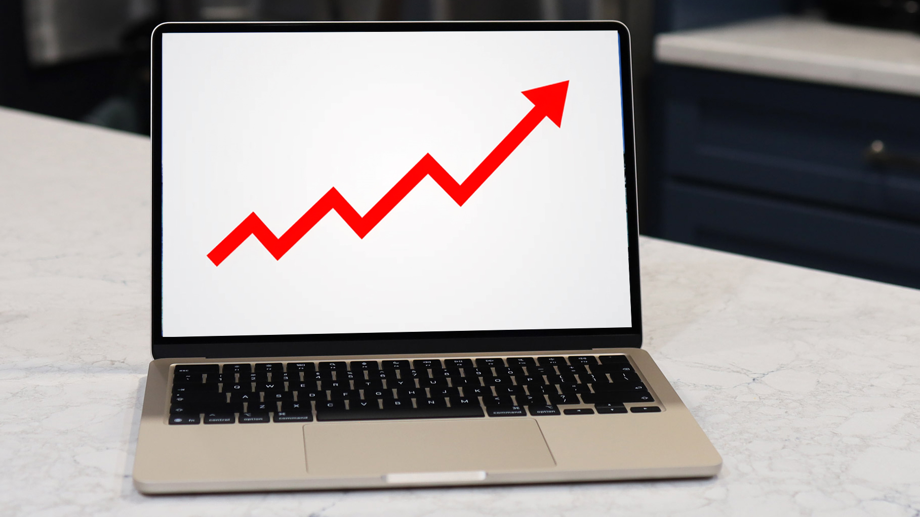A MacBook screen showing a red rising arrow