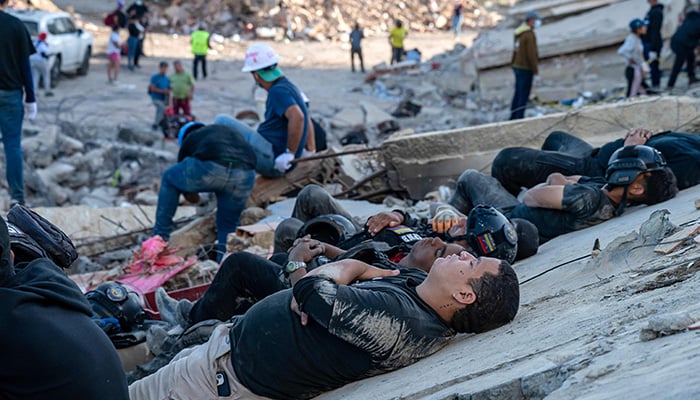 Rescuers and volunteers rest on the rubble of collapsed buildings in Caraballeda, La Guaira state, Venezuela, June 28, 2026, following earthquakes. -AFP