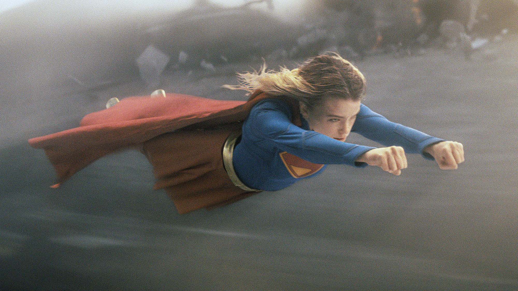 Milly Alcock's Kara Zor-El wearing her classic superhero costume as she flies through the air in the 2026 Supergirl film