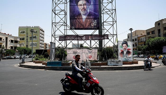 People walk past a banner with a photo of Iran's Supreme Leader, Mojtaba Khamenei, in Tehran, Iran, June 28, 2026. — Reuters