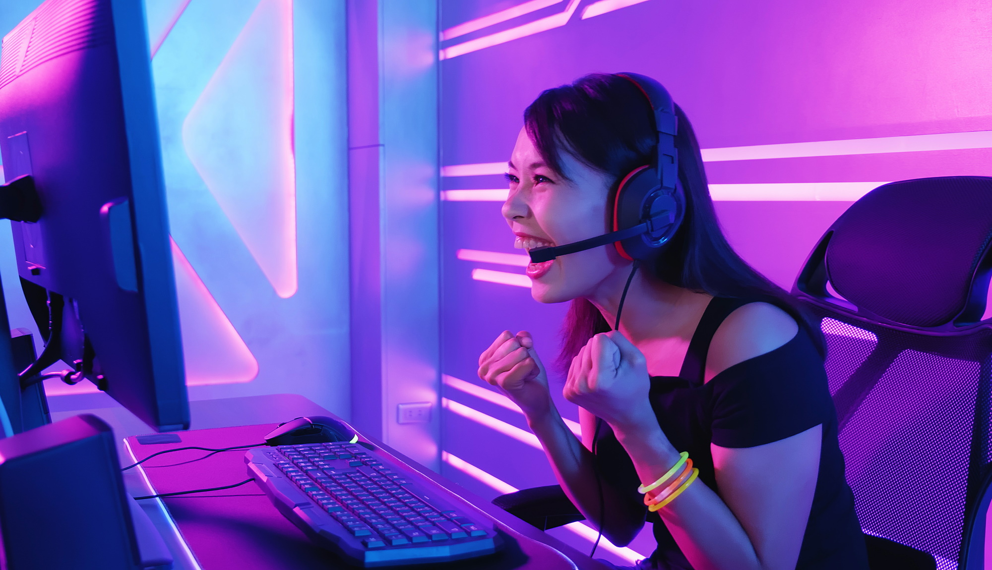 Person in front of a PC looking happy, wearing headphones