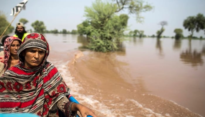 A flood victim sits on a boat as she is evacuated from her flooded house following heavy rains in Jhang, Punjab province, September 10, 2014. — Reuters