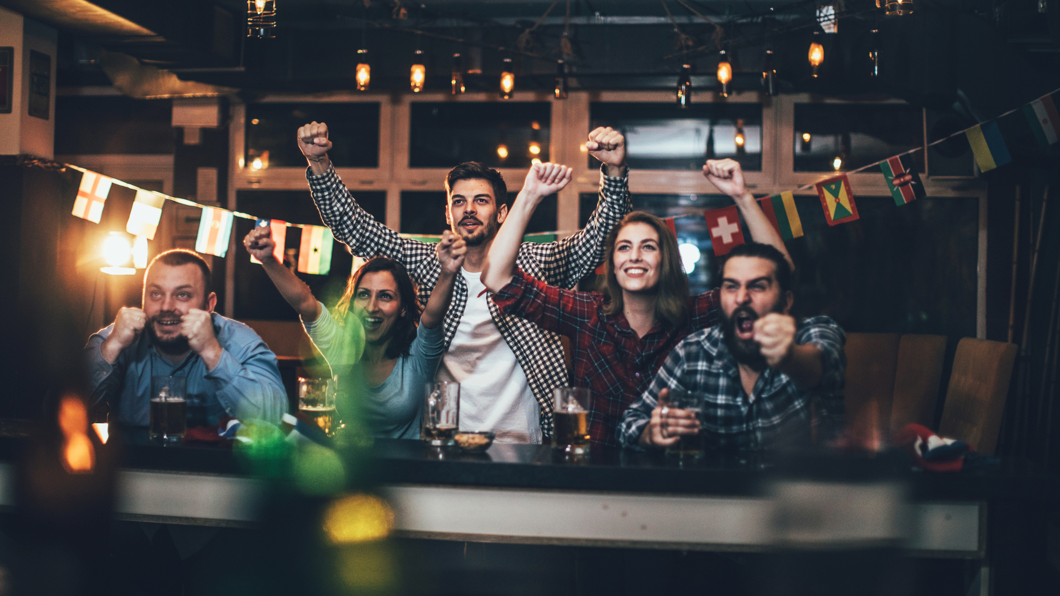A crowd enthusiastically watching a televised event
