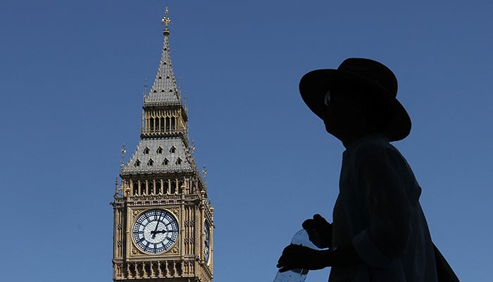 A person holds a bottle of water as they walk near Big Ben and Parliament, in London, Britain, June 23, 2026. — Reuters