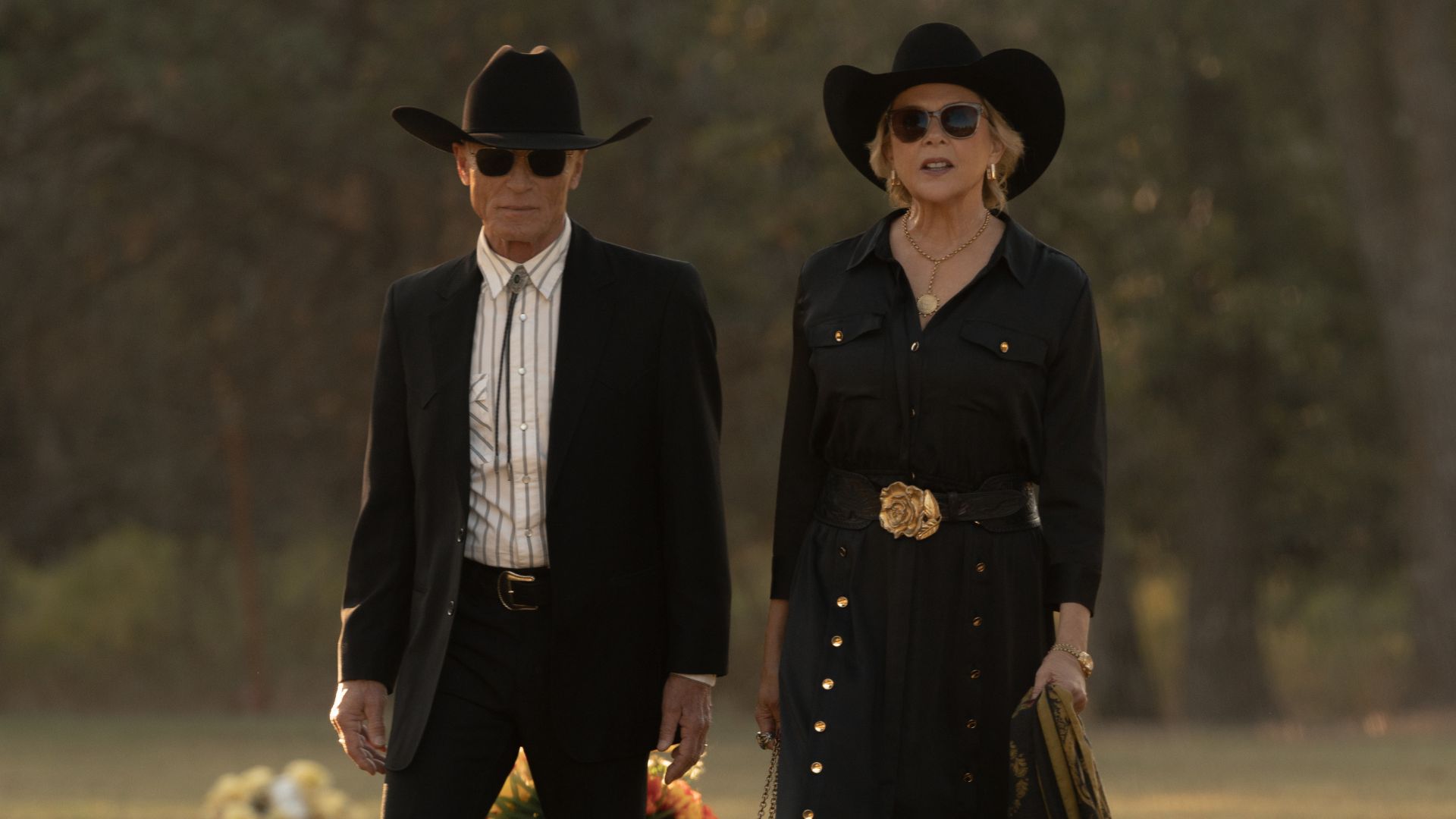 Everett and Beulah walk through a cemetery in funeral attire