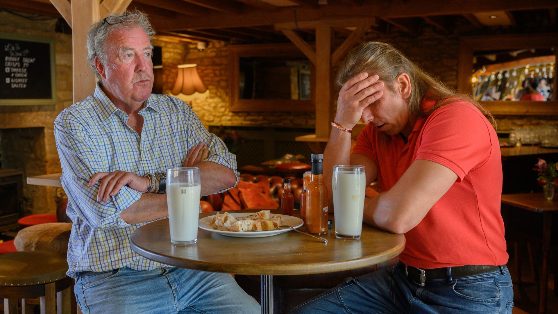 Jeremy Clarkson crosses his arms while a pub restaurant has his head in his hands
