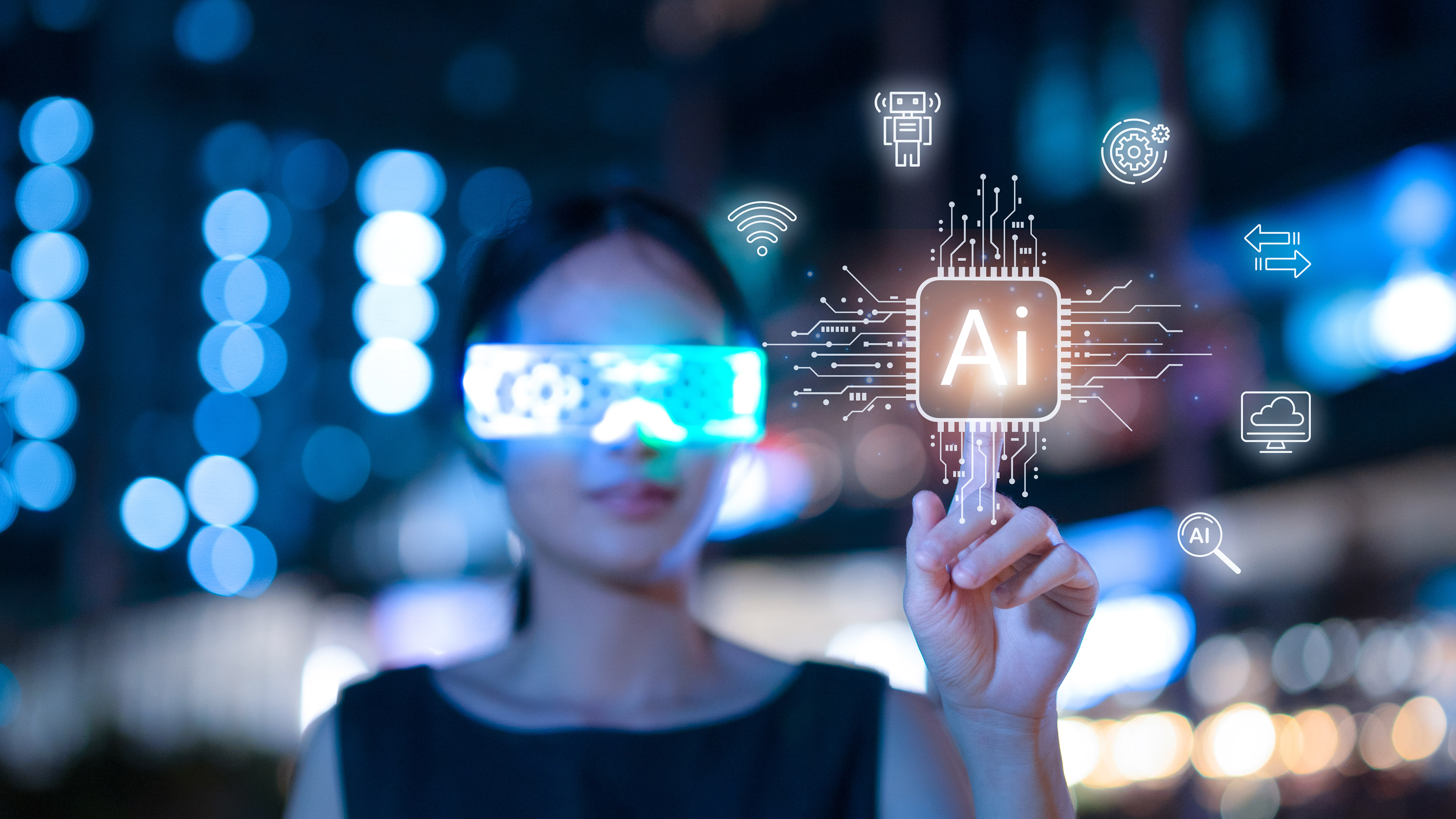 A blurred woman in the background touches the word AI, illuminated by bright yellow light, in the foreground. The woman wears smart glasses