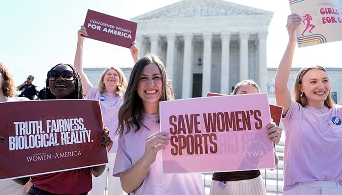 Women hold signs as they celebrate the U.S. Supreme Court's final rulings during its nine-month term, including a ruling that paved the way for states to impose restrictions on transgender student athletes, in Washington, DC, U.S., June 30, 2026. — Reuters