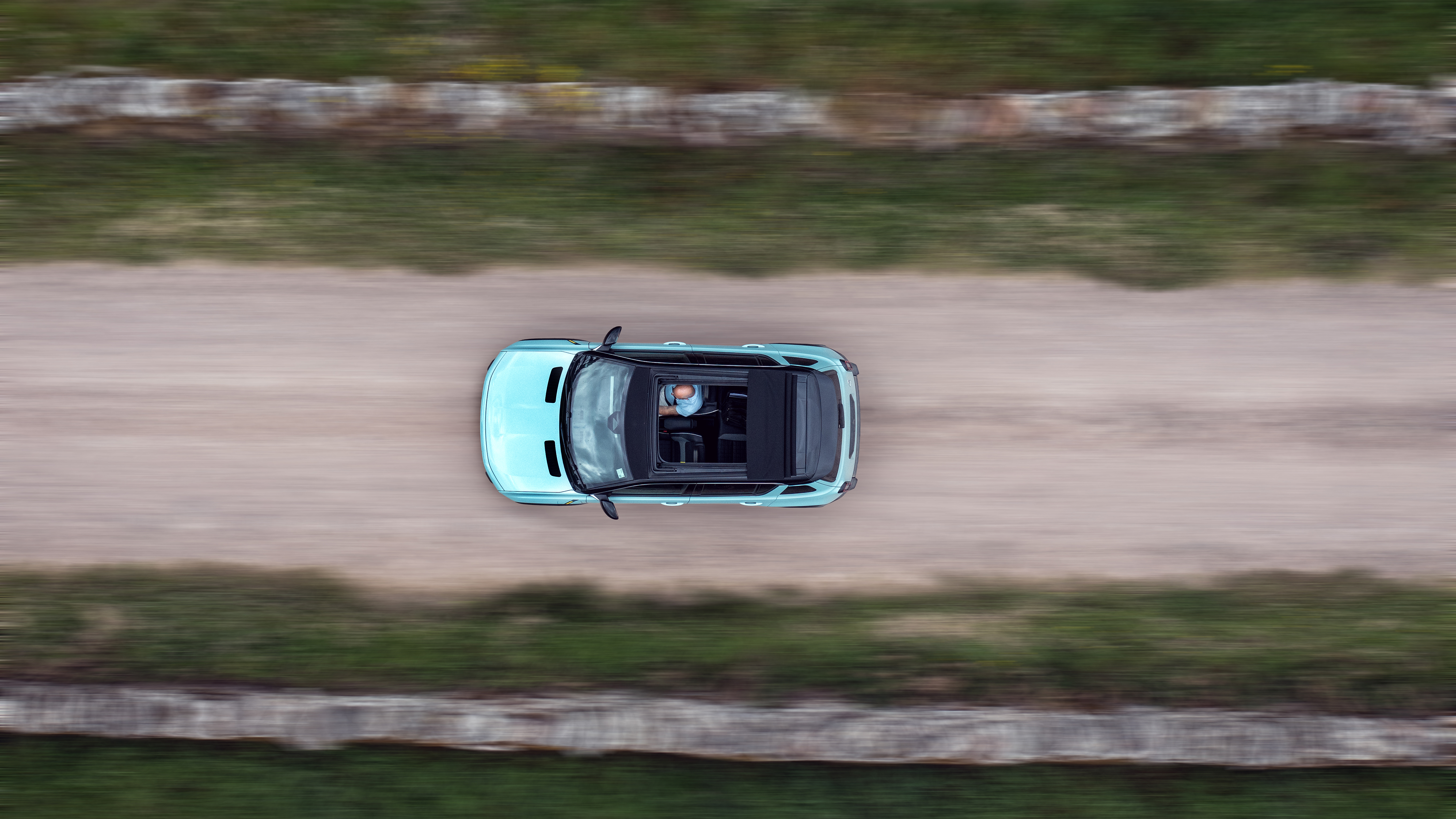 A top-down photo of an electric car driving through the countryside