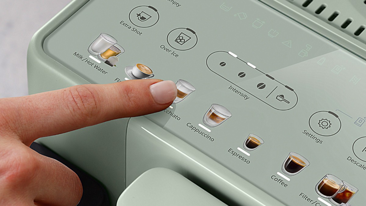Person pressing the button of the De'Longhi Rivelia Start coffee maker