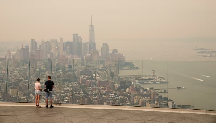 People visit the Edge observation deck as the New York City skyline and One World Trade Center are visible through a blanket of wildfire smoke in New York, the United States, July 16, 2026. — Reuters