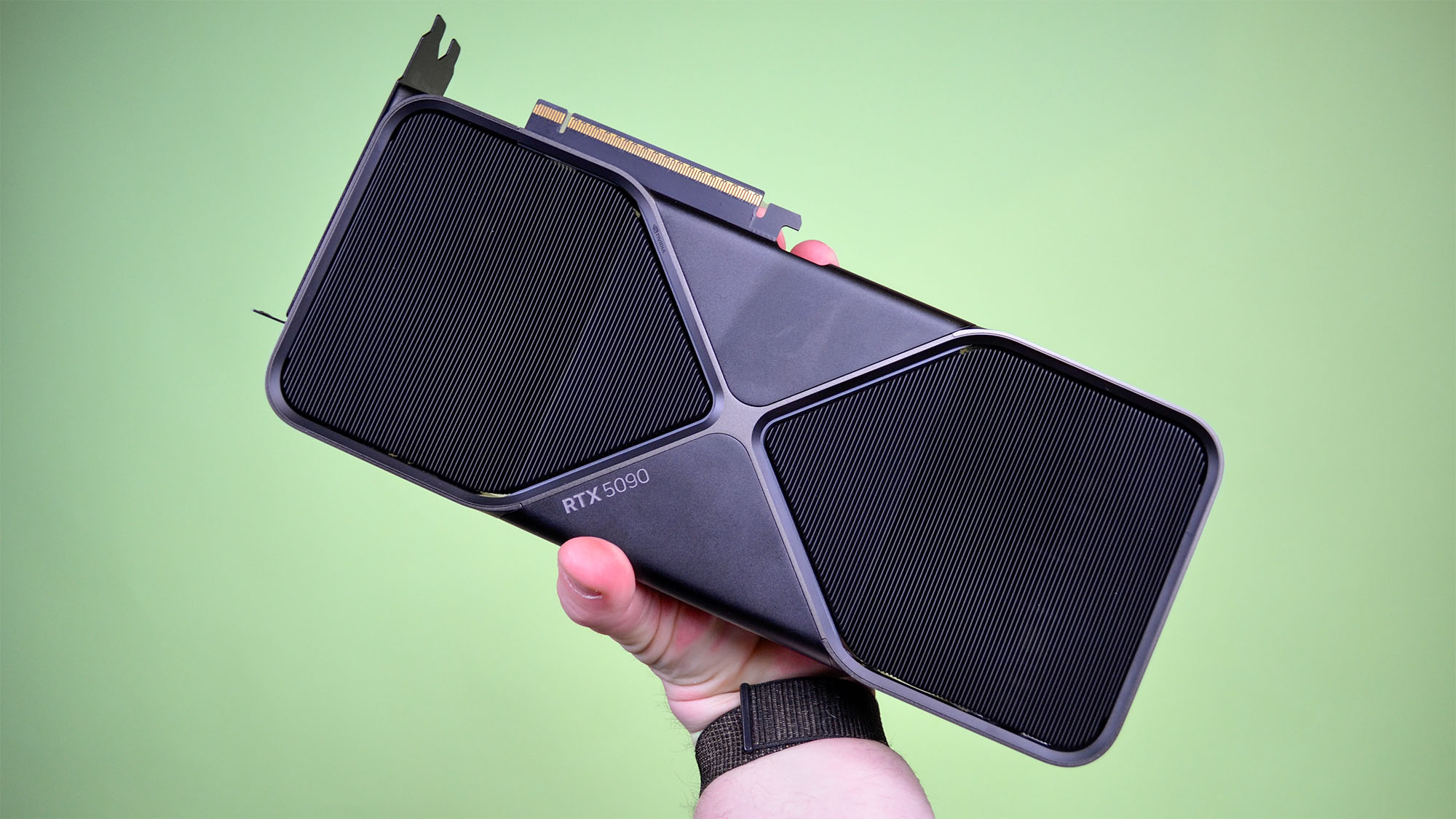 A male hand holding an RTX 5090