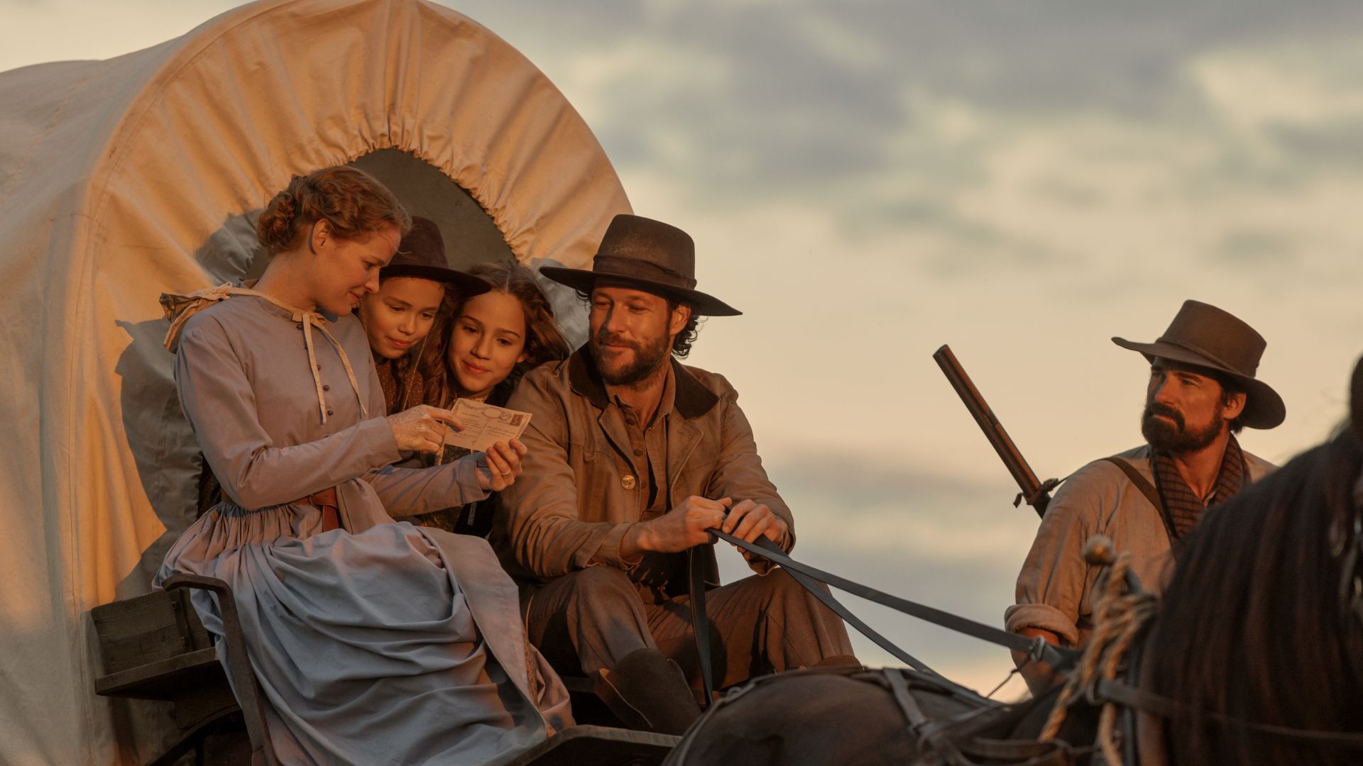 The Ingalls family looks at a letter while sitting in a wagon