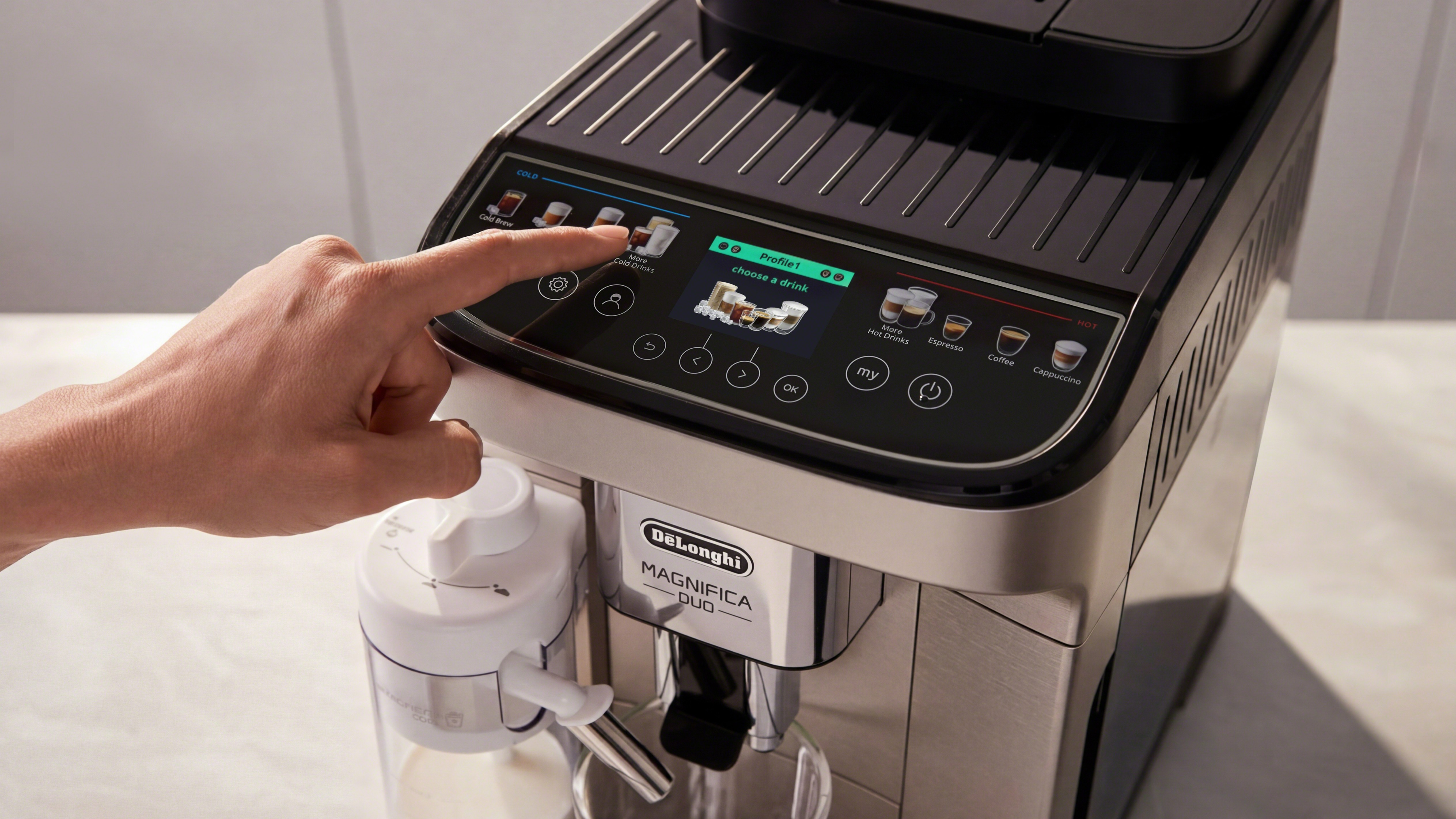 Person pressing the button of the De'Longhi Magnifica Duo coffee maker